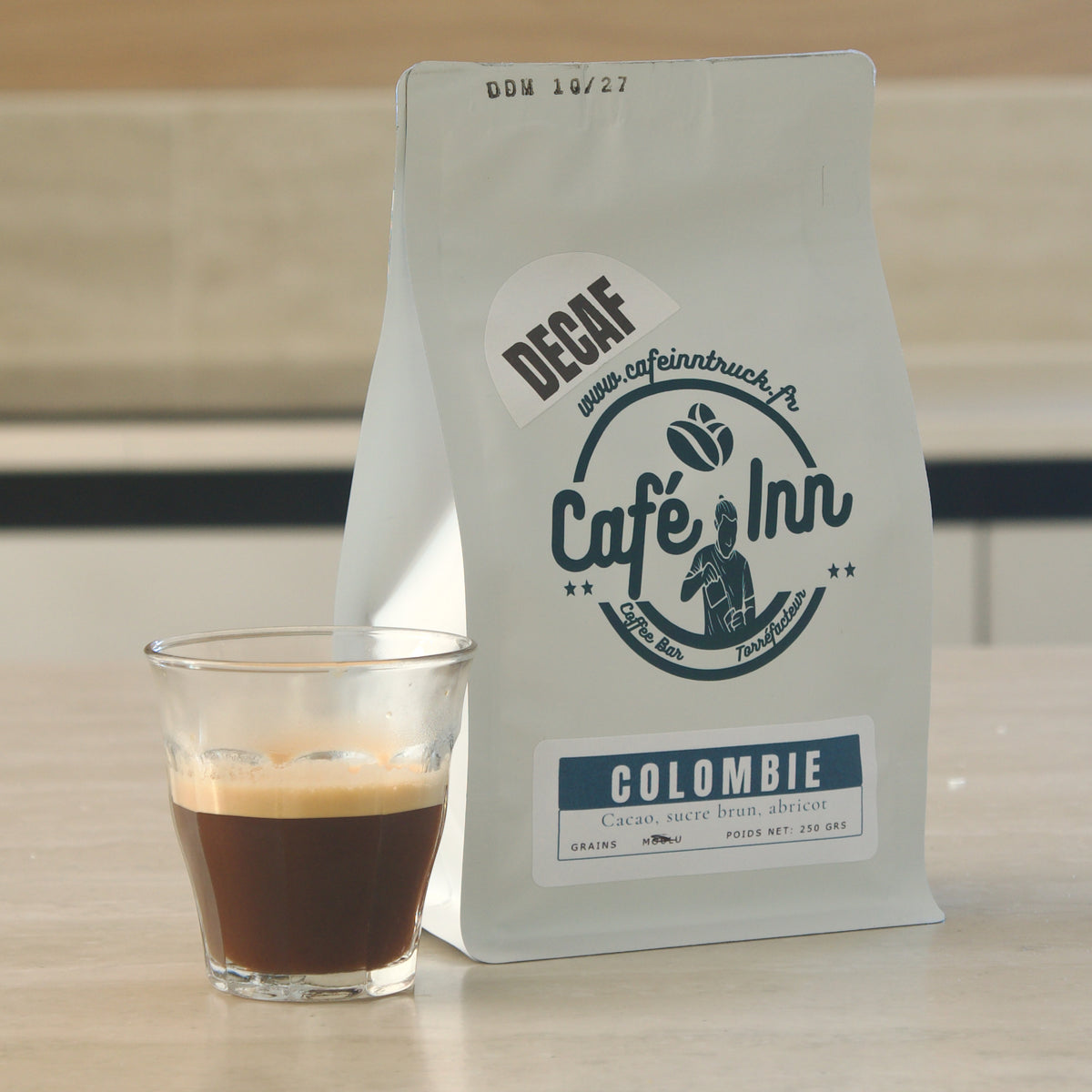 Café décaféiné Colombie Café Inn servi en espresso, avec sachet en arrière-plan