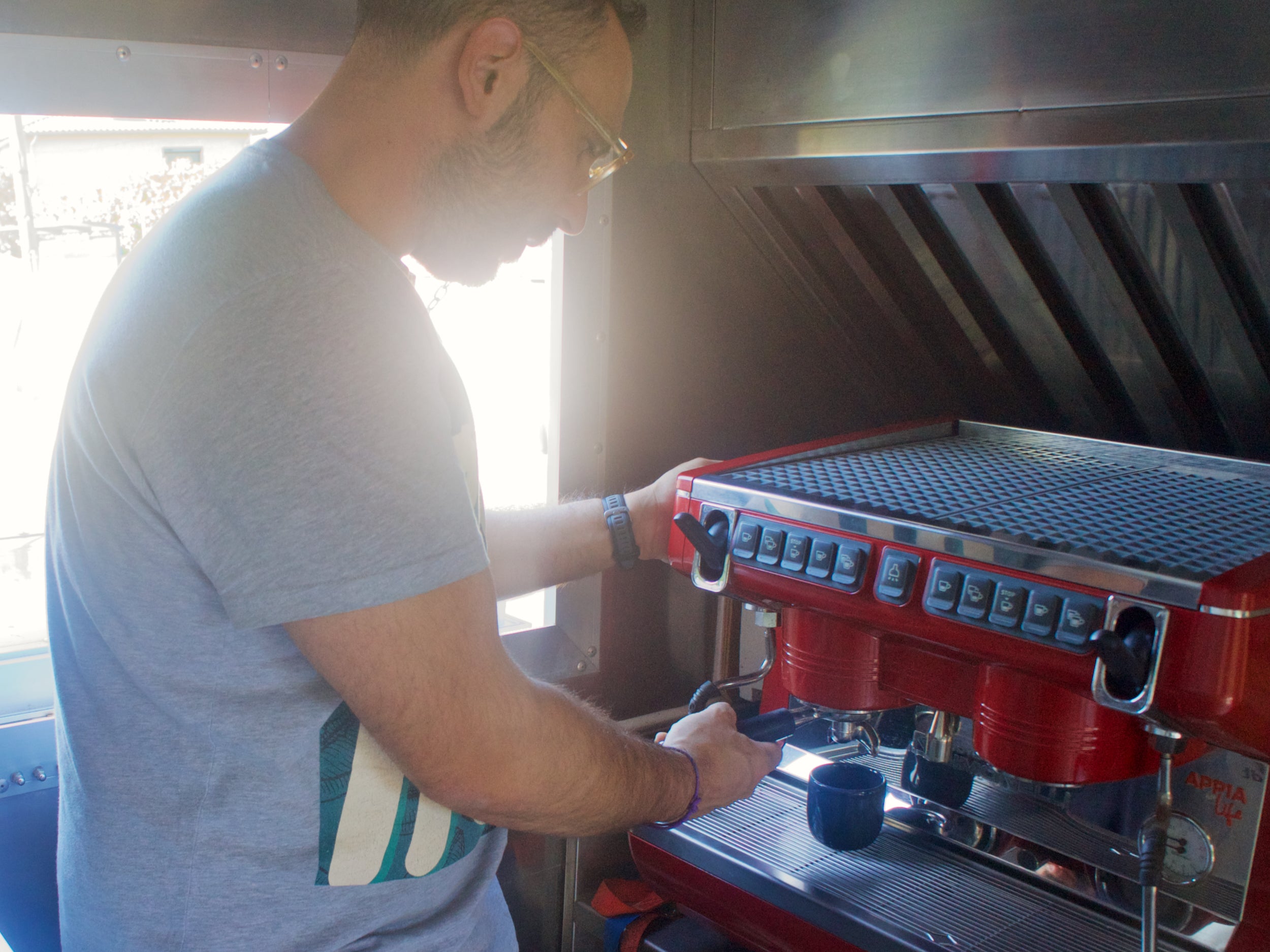 Barista Café Inn travaillant sur une machine espresso dans le coffee truck
